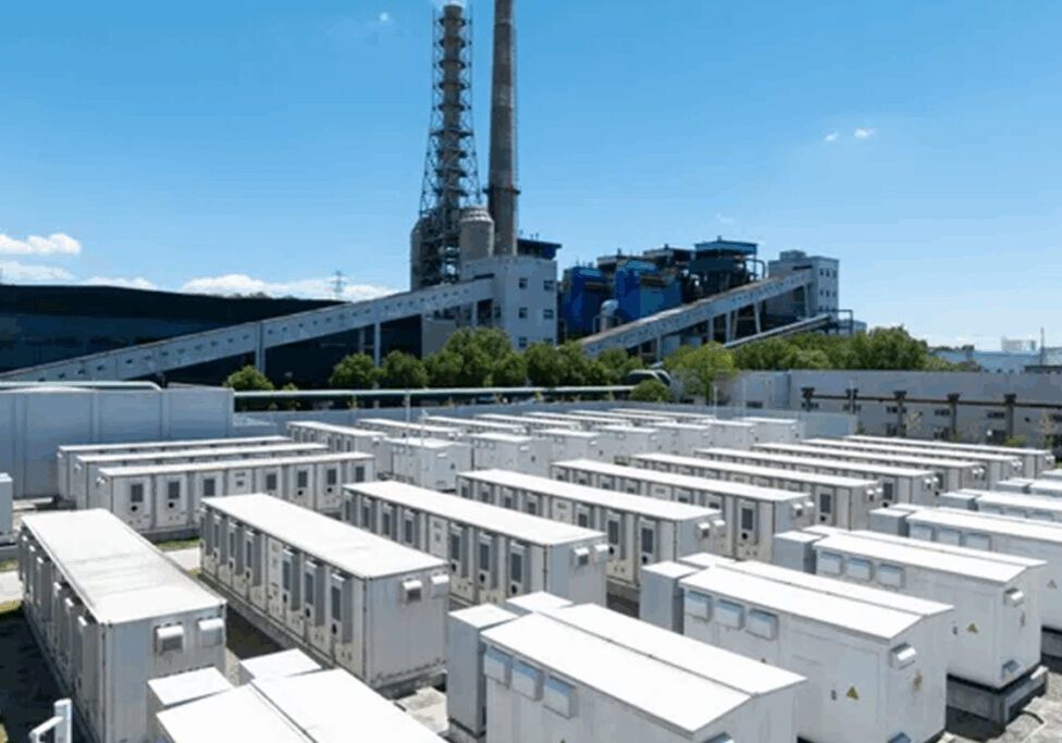 Power plant with cooling towers and electrical infrastructure under a clear sky.